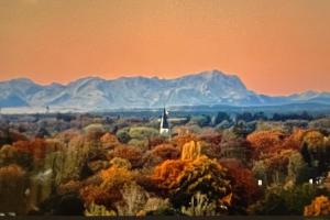 un dipinto di una foresta con montagne sullo sfondo di ALPEN-PANORAMA SUITE - Einzigartige Privatsuite hoch über München, 12tes OG, Alpenblick, Loggia, Whirlpool, 15 Minuten zum Zentrum, Ruhe und Erholung in der Stadt München für privat und geschäftlich Reisende a Monaco