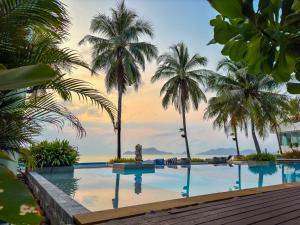 a view of a swimming pool with palm trees at Minitel By The Sea - Pranburi in Sam Roi Yot