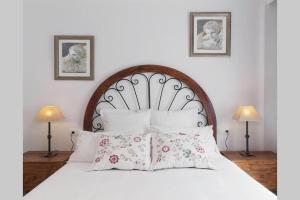 a bedroom with a large white bed with pillows at Con Encanto in Port de Soller