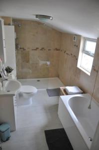 een badkamer met een bad, een toilet en een wastafel bij Lovely fisherman's cottage near beach and harbour in Whitstable