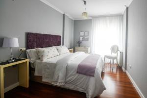 1 dormitorio con 1 cama grande y suelo de madera en Venecia1, en Pobra do Caramiñal