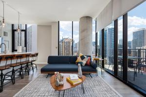 a living room with a blue couch and a table at Aurelien Spacious Apartments in the Heart of Gold Coast in Chicago