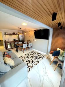 uma sala de estar com um sofá e uma televisão de ecrã plano em Pousada Doce Lar em Penha