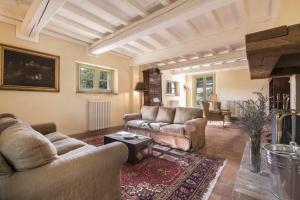 a living room with two couches and a fireplace at Borgo di Camporsevoli in Camporsevoli