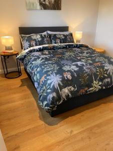 1 dormitorio con 1 cama con colcha de flores azul en NEW - The Gate Lodge at Dunnanew - 4 star- Sleeps 5 en Seaforde