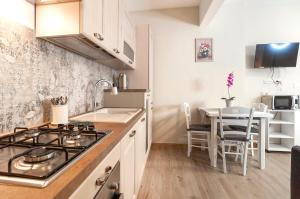 a kitchen with a stove top oven next to a table at Elegant comfy three-room apartment in Eur with parking in Rome