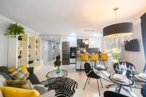 a living room with a table and yellow chairs at Venecia in A Pobra do Caramiñal