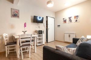 a living room with a table and a dining room at Elegant comfy three-room apartment in Eur with parking in Rome