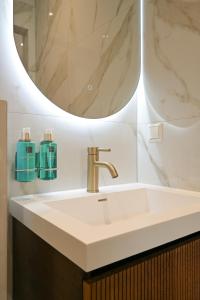 y baño con lavabo y espejo. en Novallure Downtown - Short Stay Apartments, en La Haya