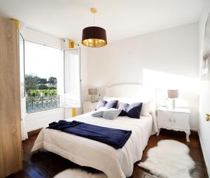 ein weißes Schlafzimmer mit einem großen Bett und einem Fenster in der Unterkunft Casa Romero Garden in Vilanova de Arousa