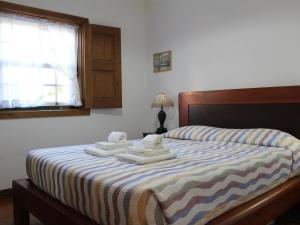 1 dormitorio con 1 cama con toallas en Beautiful cottage on the estate of a farm, en Ponte de Lima