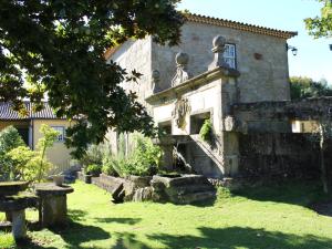 un vecchio edificio in pietra con una nicchia in un cortile di Beautiful cottage on the estate of a farm a Ponte de Lima