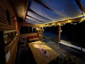 een veranda met een tafel en verlichting bij Ferienhaus im Wald in Edelschrott