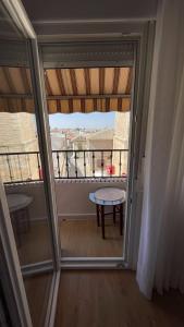a room with a balcony with a window and a table at Vivienda Vista Mayor 3 Dorm Íntegro cerca de Madrid y Toledo in La Guardia