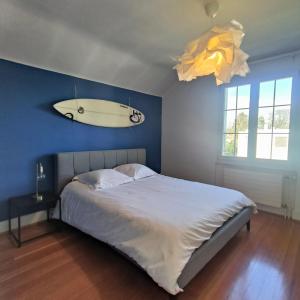 a bedroom with a bed with a surfboard on the wall at Maison de charme au cœur de Genève ! in Geneva