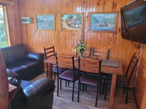 a dining room with a table and a couch at Cabañas Buen Recuerdo in Puyehue