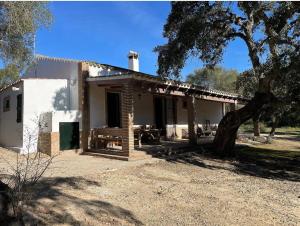 une maison avec un arbre devant dans l'établissement Casa Rural Los Murtales, à Alcalá de los Gazules