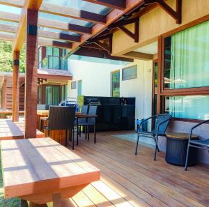 a patio with tables and chairs on a wooden deck at Reserva dos Carneiros - Flat-Apartamento em Carneiros in Tamandaré