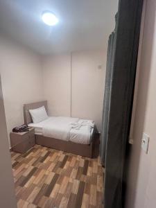 a small bedroom with a bed and a wooden floor at Cairo de casa hostel in Cairo