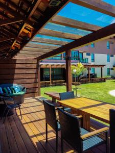 a wooden deck with a table and chairs on it at Reserva dos Carneiros - Flat-Apartamento em Carneiros in Tamandaré