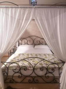 a bed with a canopy and white curtains at BGY Airport Guesthouse in Orio al Serio