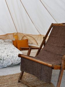 uma cadeira de madeira sentada em frente a uma tenda em Yurt in Avocado garden em Güímar
