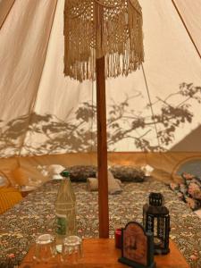 Yurt in Avocado garden في غيمار: خيمة مع طاولة مع نظارة وزجاجة