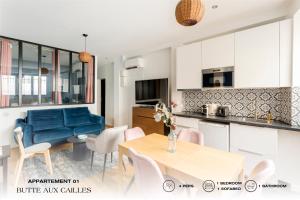 uma cozinha e sala de estar com uma mesa e um sofá azul em Beauquartier - Butte aux cailles em Paris