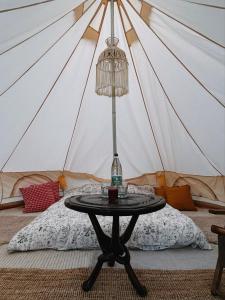 Yurt in Avocado garden في غيمار: طاولة أمام خيمة مع سرير