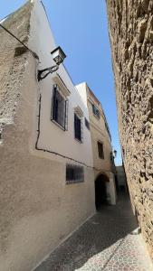 ein altes Gebäude mit Tür und Straße in der Unterkunft Dar Dada in Safi