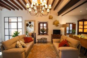 a living room with two couches and a chandelier at Camp de sa mar in Port de Soller