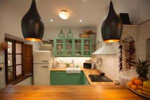 a kitchen with green cabinets and a white refrigerator at Camp de sa mar in Port de Soller