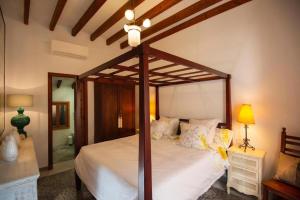 a bedroom with a canopy bed with white sheets at Camp de sa mar in Port de Soller