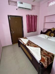 a bedroom with a bed and a door at Hotel R residence in Srīsailam