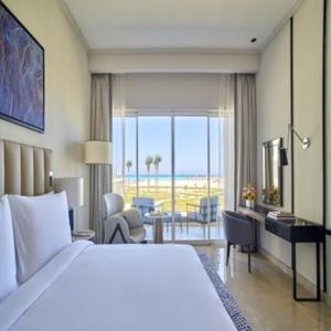 a hotel room with a bed and a view of the ocean at Address Beach Resort Marassi in El Alamein