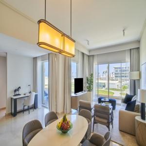Address Beach Resort Marassi في العلمين: غرفة معيشة مع طاولة وغرفة معيشة مع أريكة
