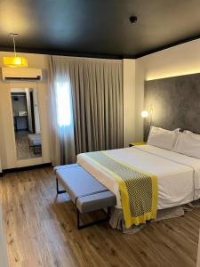 Un dormitorio con una cama grande y una ventana en Oasis Tower Hotel, en Ribeirão Preto