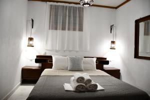 ein Schlafzimmer mit einem Bett mit Handtüchern darauf in der Unterkunft Heliofos Apartments in Stomio