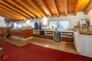a large kitchen with wooden floors and wooden ceilings at Hotel Riz B.B in San Genesio ed Uniti