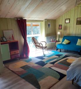 a living room with a blue couch and a rug at Gîte de la Ouedolle in Sengouagnet