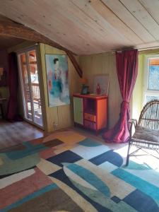 a room with a table and a chair and a rug at Gîte de la Ouedolle in Sengouagnet