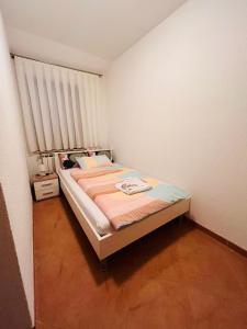 a small bedroom with a bed and a window at Ani Apartments in Umag