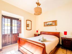 a bedroom with a bed and a window and a door at Casa do Candeeiro in Óbidos