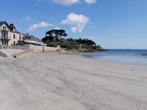 サン・ポル・ド・レオンにあるTy Pempoul - logement 2 chambres - 100 m de la plageの海と家の空きビーチ