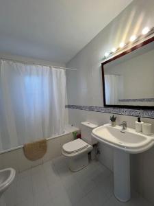 a bathroom with a sink and a toilet and a mirror at Gran Chalet a 13 min de Sevilla in Gelves