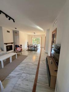 a large living room with a couch and a tv at Gran Chalet a 13 min de Sevilla in Gelves