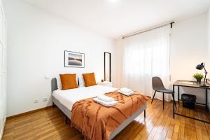 a bedroom with a bed with a desk and a chair at Flat Armada II - Apartamento T5 junto ao BragaParque in Braga