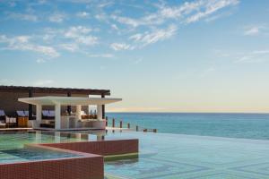 a resort with a swimming pool and the ocean at Grand Velas Boutique Hotel in San José del Cabo