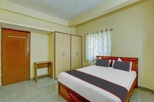 a bedroom with a large bed and a window at Collection O Relax Stay Apartments in Bangalore
