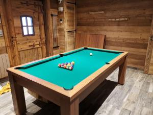 a pool table with balls on it in a room at Chalet 10 pers sauna & SPA La tanière des Vosges in La Bresse